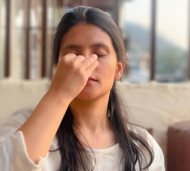 A young woman practising alternate nostril breathing