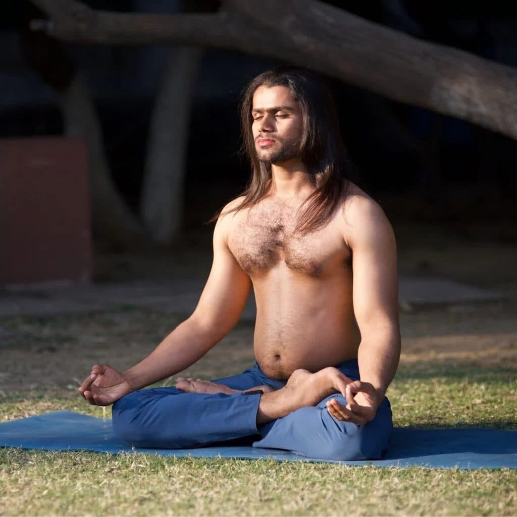 Yogacharya Manish seated in meditation outdoors